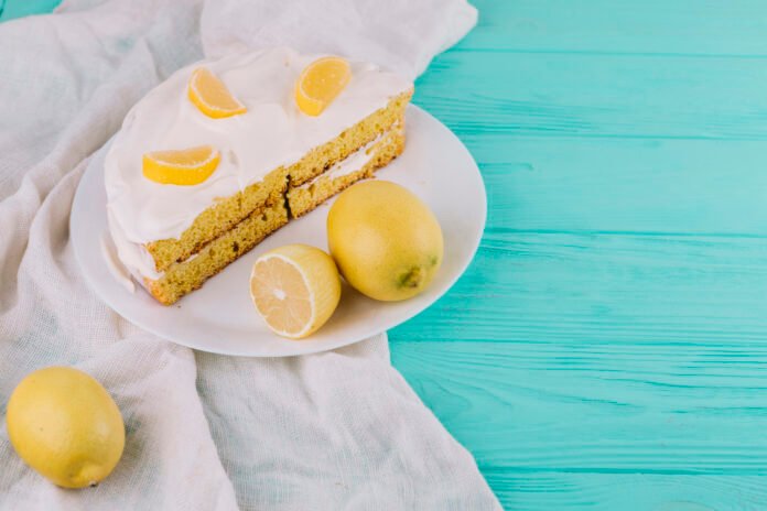 Bolo de limão com cobertura de merengue decorado com fatias de limão em prato branco