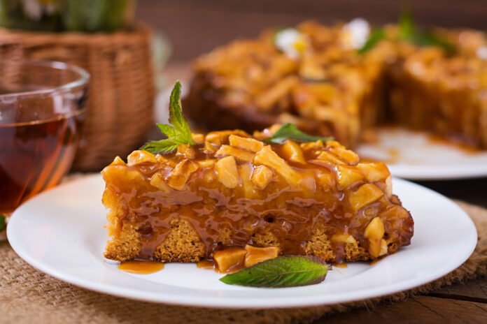 Bolo de abacaxi fofinho coberto com calda de caramelo e folhas de hortelã.