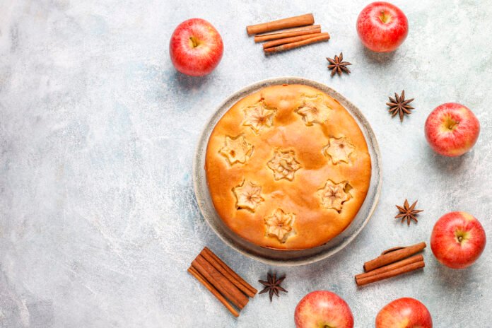 Bolo de Aveia com Maçã e Canela decorado com fatias de maçã, paus de canela e anis estrelado.