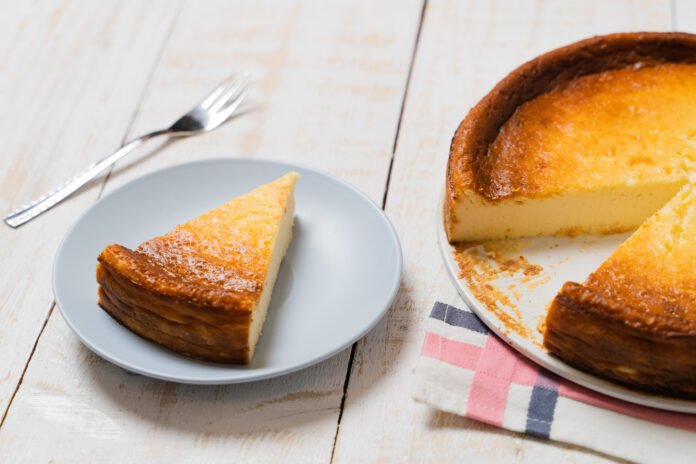 Fatias de bolo de tapioca caseiro sem glúten em um prato claro, com uma textura macia e dourada.