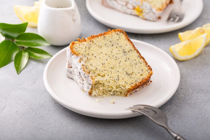 Fatia de bolo de limão siciliano com sementes de chia sobre um prato branco.