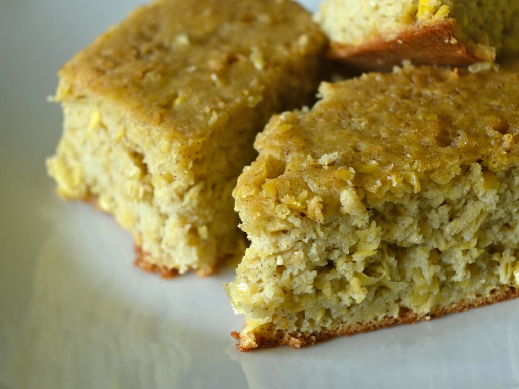 Fatias de bolo integral de fubá com erva-doce em um prato branco.