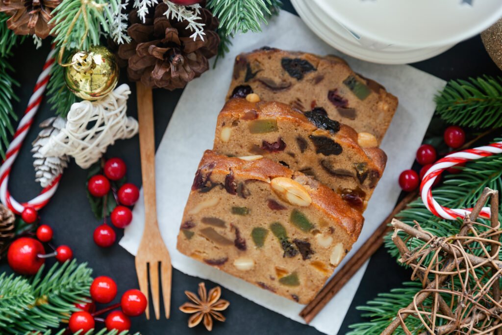 Fatias do bolo temático de Natal com frutas secas e especiarias decoradas com itens natalinos.